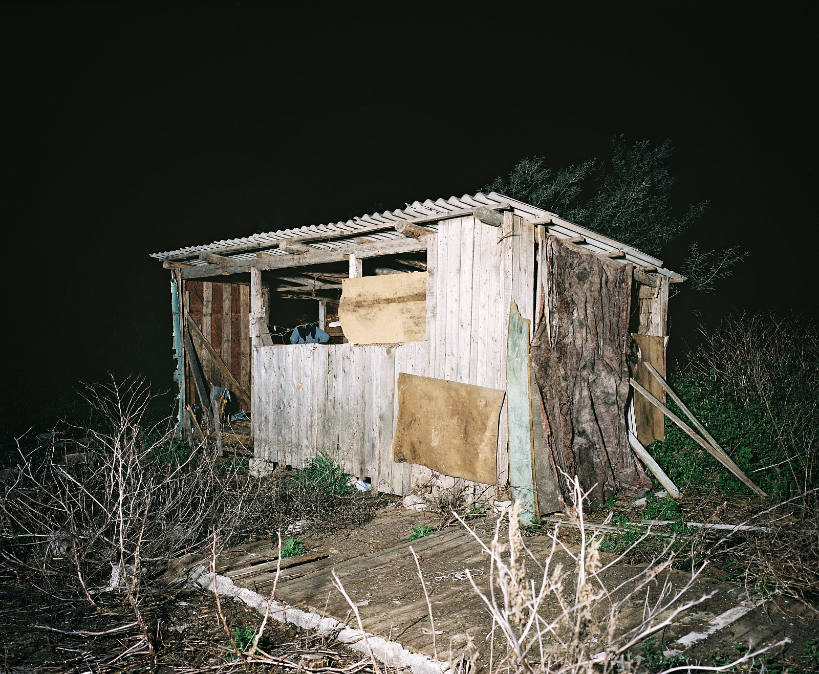 Ivan sleeps in a cowshed on a vacant lot behind the Olympic construction site in Sochi, Russia. He is waiting for a payment of 50,000 rubles (EUR1,250) for the past months' work. The new boss says that he has already been paid. The attorney general has written them a letter saying that they can strike pending payment of their money. But Ivan is no longer welcome on the construction site. For each one of them, ten others are waiting in line, says the boss. Because they have been eating into their savings for months, they will never make it home. Train travel is expensive. Ivan hasn't had contact with his family in Azov for weeks. He is embarrassed that he can't send money. His wife and two daughters will now have to fend for themselves. From his cowshed, he can see the stadiums growing larger every day.